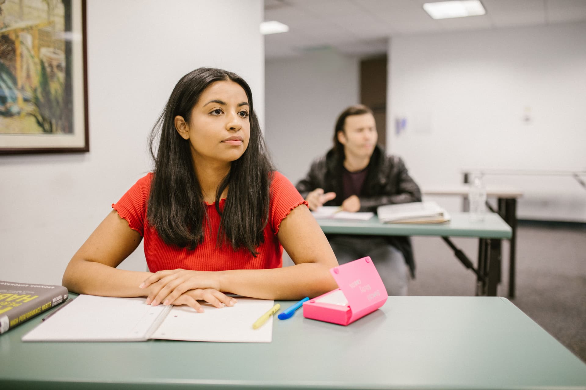 Students seated in a lecture room taking notes during a class