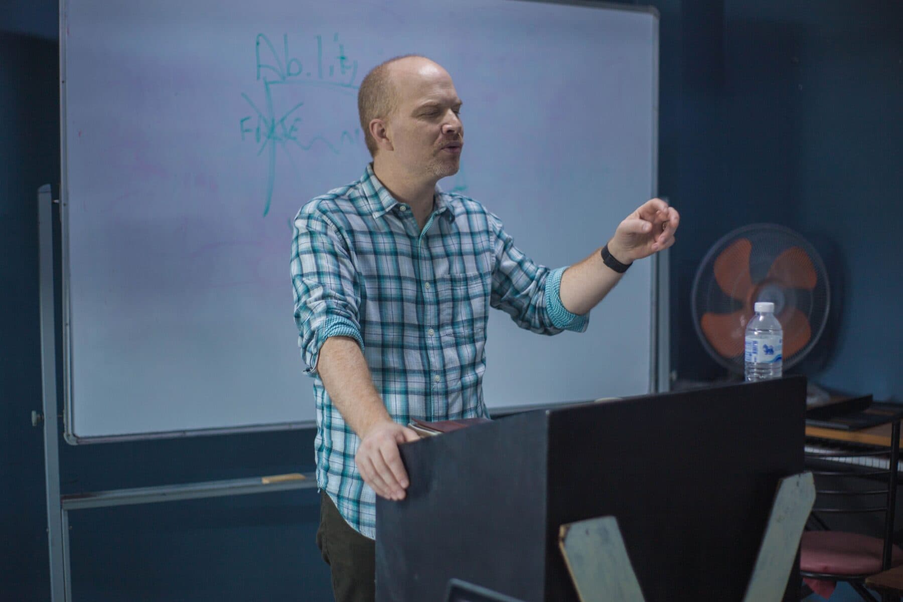 A lecturer explaining an idea at a whiteboard