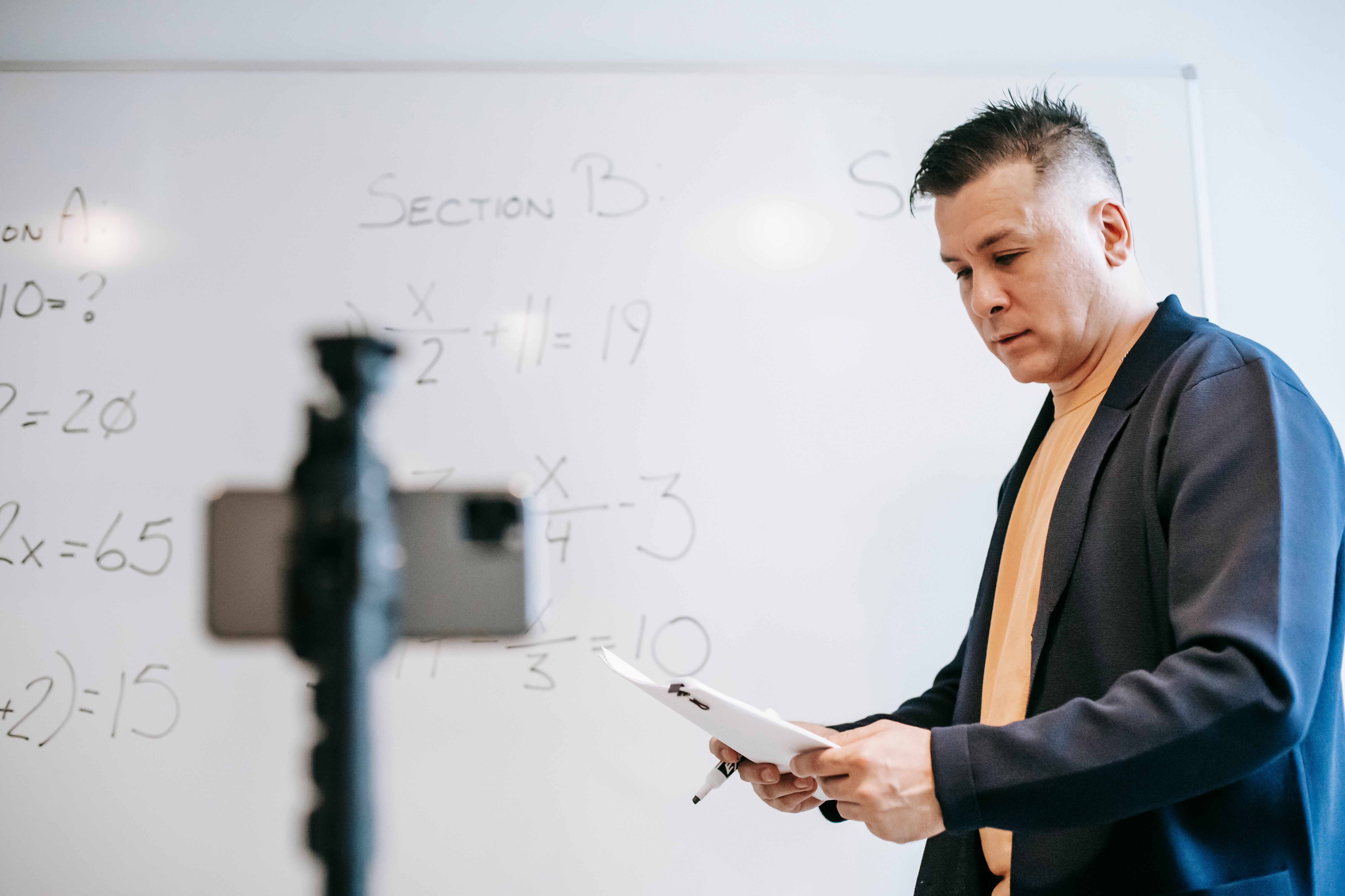 An educator explaining a diagram on a whiteboard to an online class